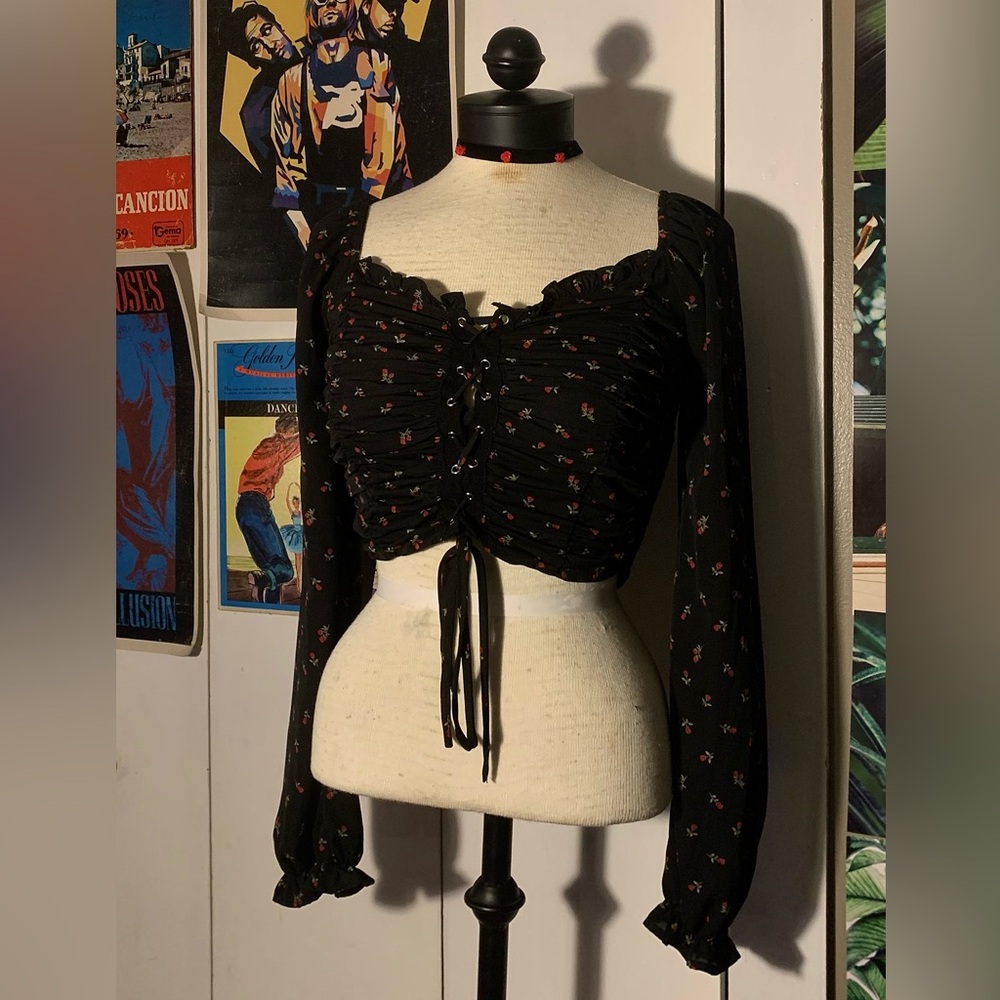 Black long sleeve crop top with rose print, lace-up front & ruffle details